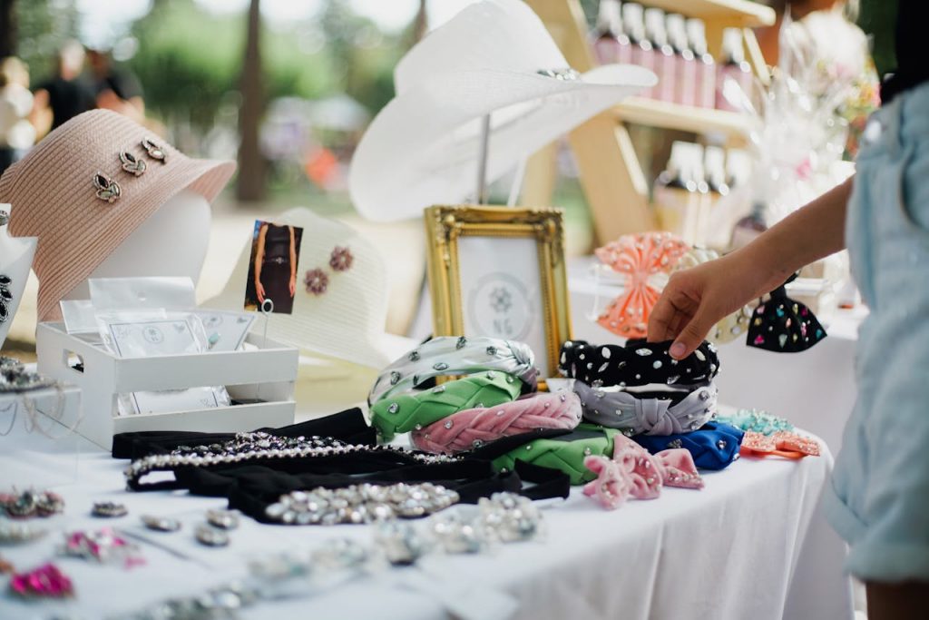Colorful display of fashion accessories at outdoor market stall featuring hats and headbands.